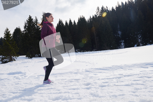 Image of yougn woman jogging outdoor on snow in forest