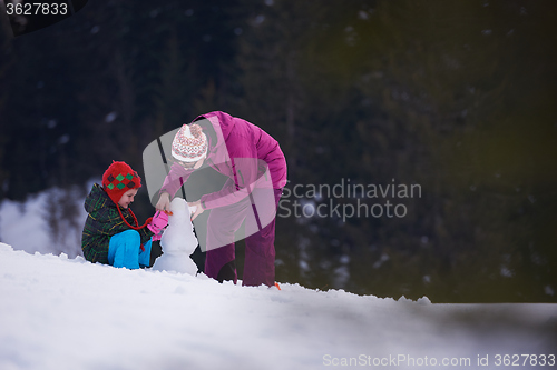 Image of happy family building snowman