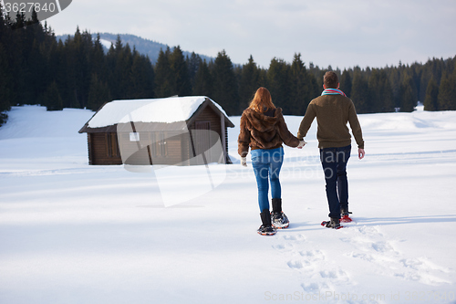 Image of couple having fun and walking in snow shoes