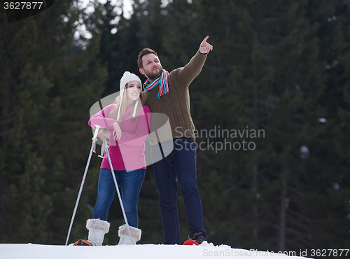 Image of couple having fun and walking in snow shoes