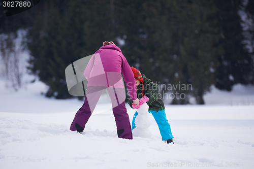 Image of happy family building snowman