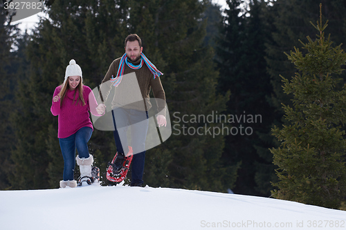 Image of couple having fun and walking in snow shoes