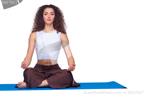 Image of Studio shot of a young fit woman doing yoga exercises.