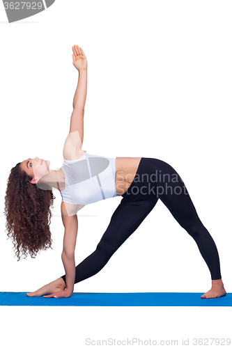 Image of Studio shot of a young fit woman doing yoga exercises.