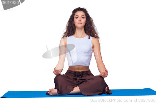 Image of Studio shot of a young fit woman doing yoga exercises.