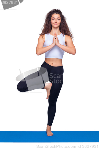 Image of Studio shot of a young fit woman doing yoga exercises.