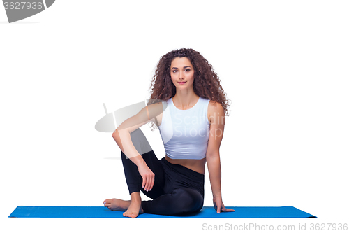 Image of Studio shot of a young fit woman doing yoga exercises.