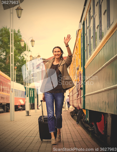 Image of smiling pretty middle-aged woman goes in a retro trip