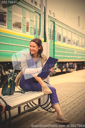 Image of beautiful middle-aged woman traveler on a railway station