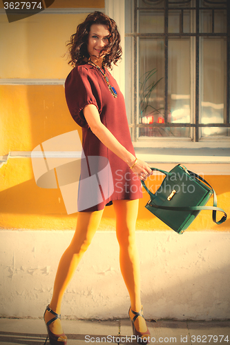 Image of laughing middle-aged woman with a green handbag