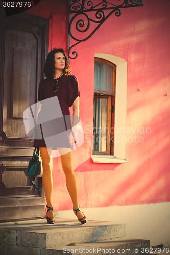 Image of pretty middle-aged woman in a burgundy dress and pantyhose musta