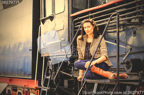 Image of beautiful woman near an old steam locomotive