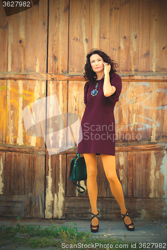 Image of woman in a burgundy dress with a handbag