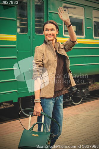 Image of beautiful middle-aged woman waving good-bye