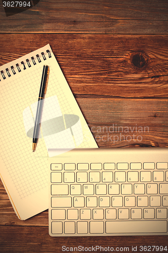 Image of notebook pen and computer keyboard