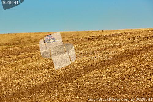 Image of Agricultural Landscape. Tractor working on the field.
