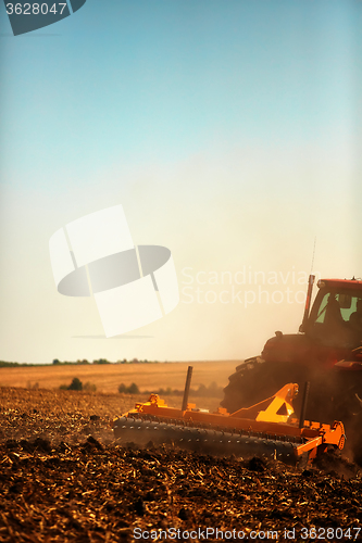 Image of Agricultural Landscape. Tractor working on the field.