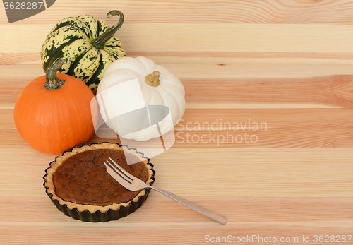 Image of Three pumpkins with small pumpkin pie and fork