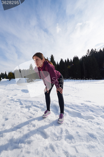 Image of yougn woman jogging outdoor on snow in forest