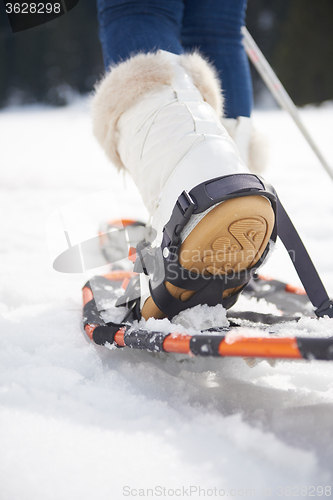 Image of couple having fun and walking in snow shoes