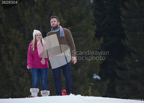 Image of couple having fun and walking in snow shoes