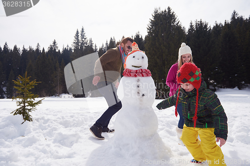 Image of happy family building snowman