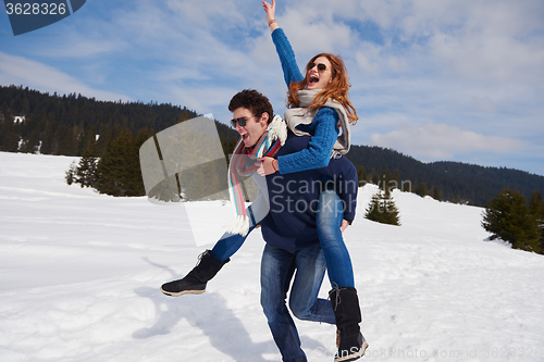 Image of happy young couple having fun on fresh show on winter vacation