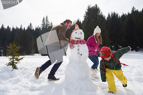 Image of happy family building snowman