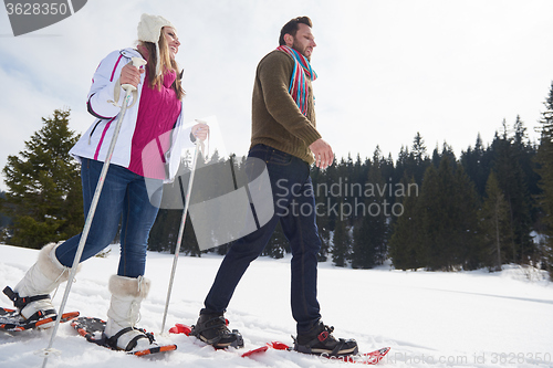 Image of couple having fun and walking in snow shoes