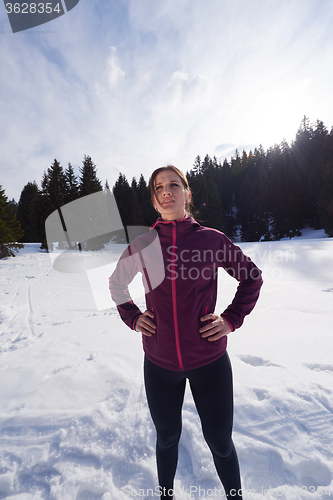 Image of yougn woman jogging outdoor on snow in forest