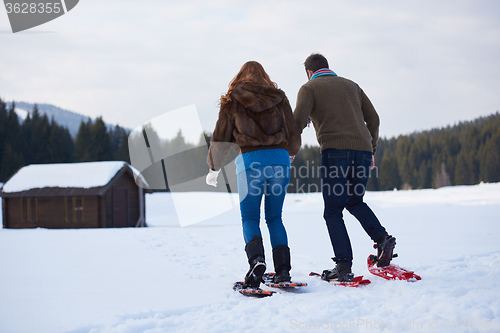Image of couple having fun and walking in snow shoes