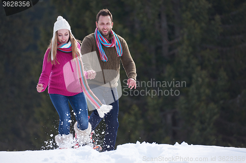 Image of couple having fun and walking in snow shoes