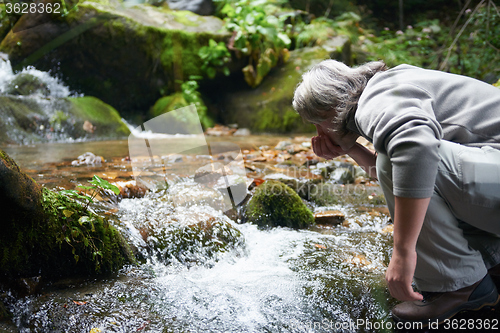 Image of man drinking fresh water from spring