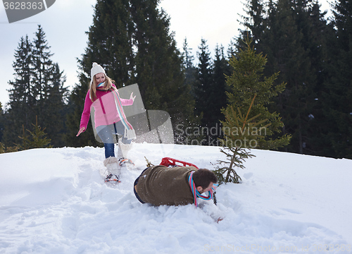 Image of couple having fun and walking in snow shoes