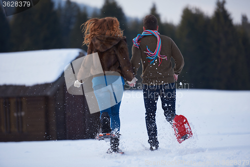 Image of couple having fun and walking in snow shoes