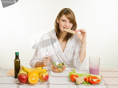 Image of Young girl bites the bread, eating their vegetarian vegetable salad