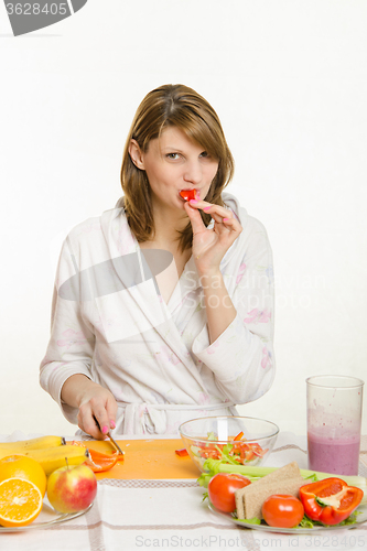 Image of A young girl having fun eating a vegetarian pepper