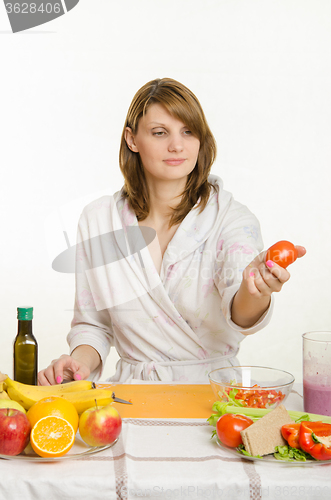 Image of She picked up a tomato preparing a salad