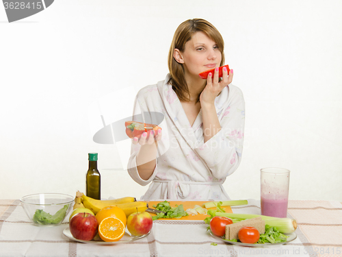 Image of Young girl with a vegetarian delight sniffing pepper