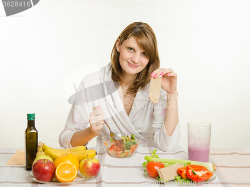Image of Young girl eats vegetarian vegetable salad and vegetable snack loaf