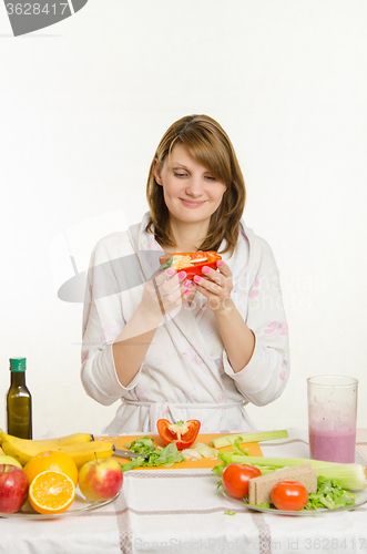 Image of Young girl with a vegetarian delight looks at the bell pepper