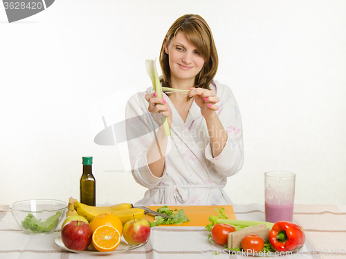 Image of Happy housewife cleans celery