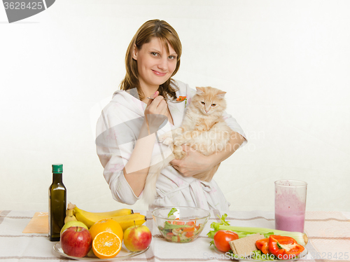 Image of The young girl offers a vegetarian cat food