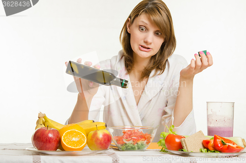 Image of Young girl poured the oil into a vegetarian vegetable vitamin salad