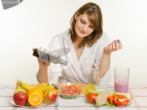 Image of Housewife pours oil into a freshly prepared vegetable vitamin salad