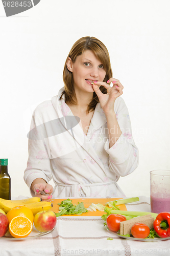 Image of A young girl tries to slice vegetarian chopped celery for vegetable salad