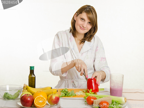 Image of Young girl with a vegetarian delight cuts pepper