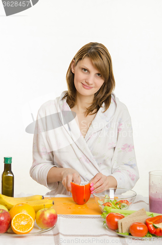 Image of Young girl cuts pepper vegetarian