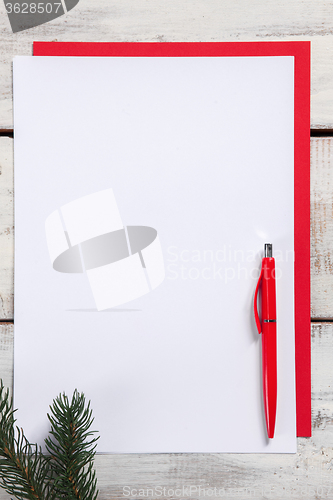 Image of The blank sheet of paper on the wooden table with a pen 