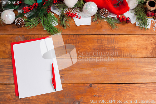 Image of The blank sheet of paper on the wooden table with a pen 